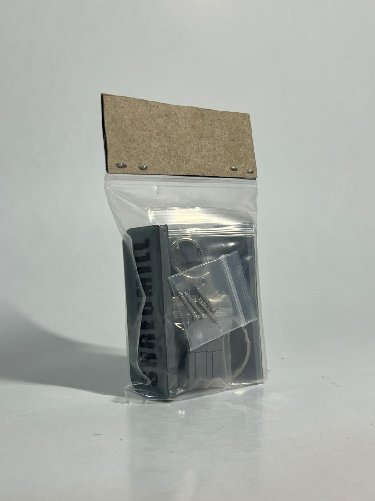 Rear view of the packaged Shredmill keychain and its components
